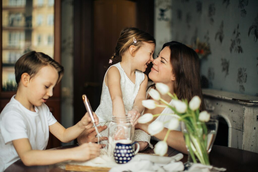 Happy family scene of a woman engaging with her children during playtime.